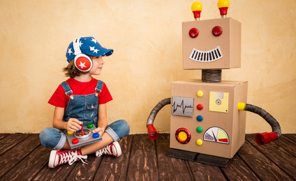 Happy child playing with toy robot at home. Retro toned
